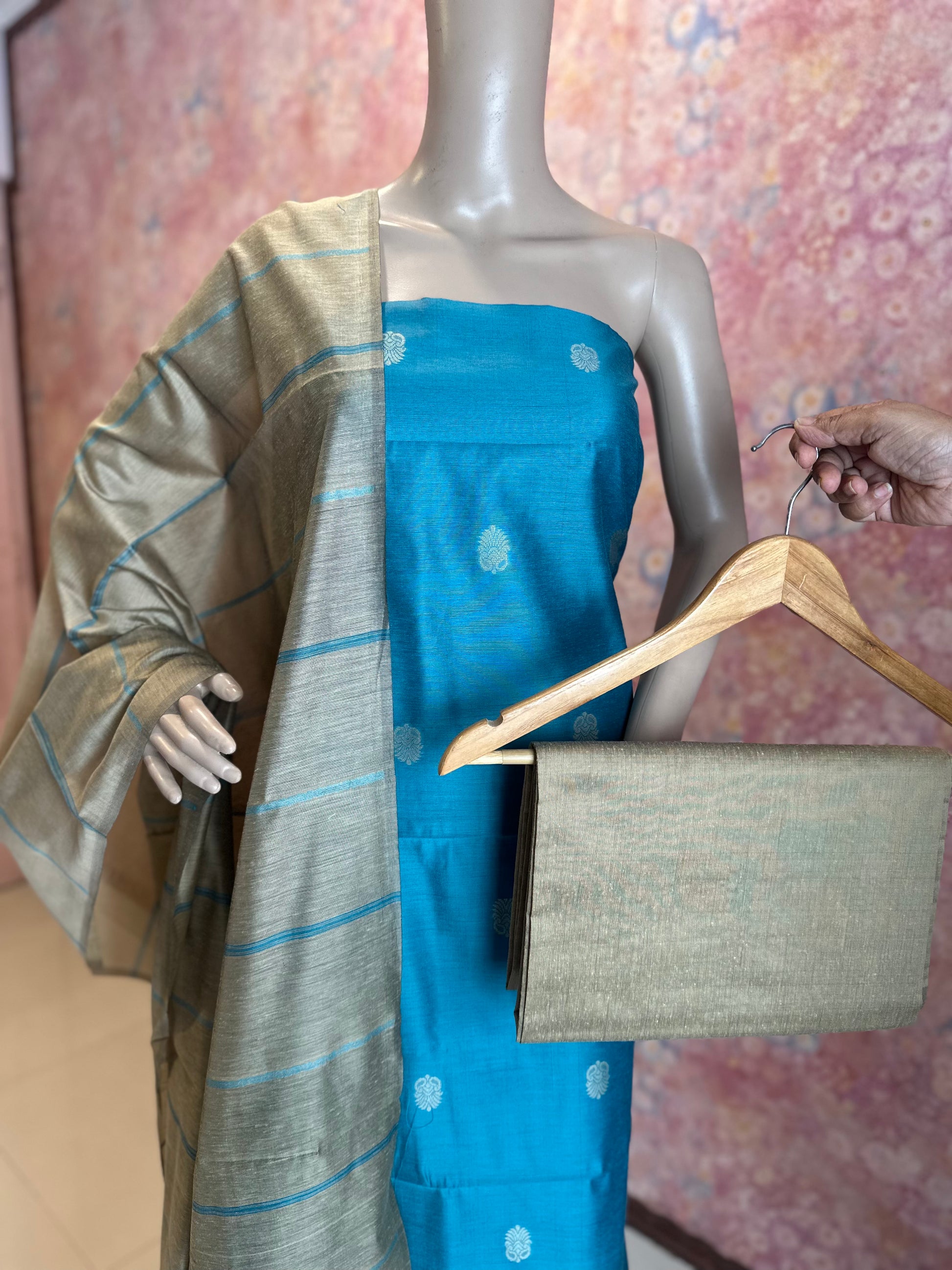 Close view of Light Blue top fabric, contrasting dupatta and plain bottom fabric displayed on a hanger.