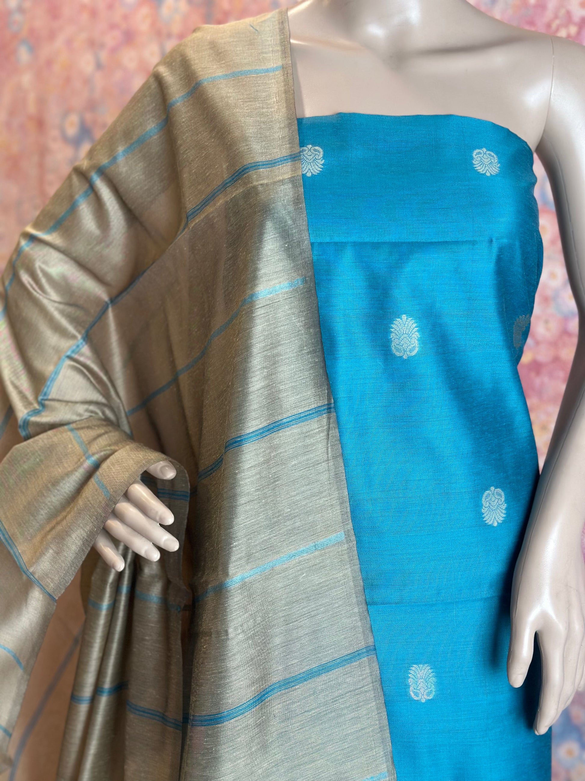 Close-up of woven motifs on Light Blue silk cotton fabric beside the striped dupatta.