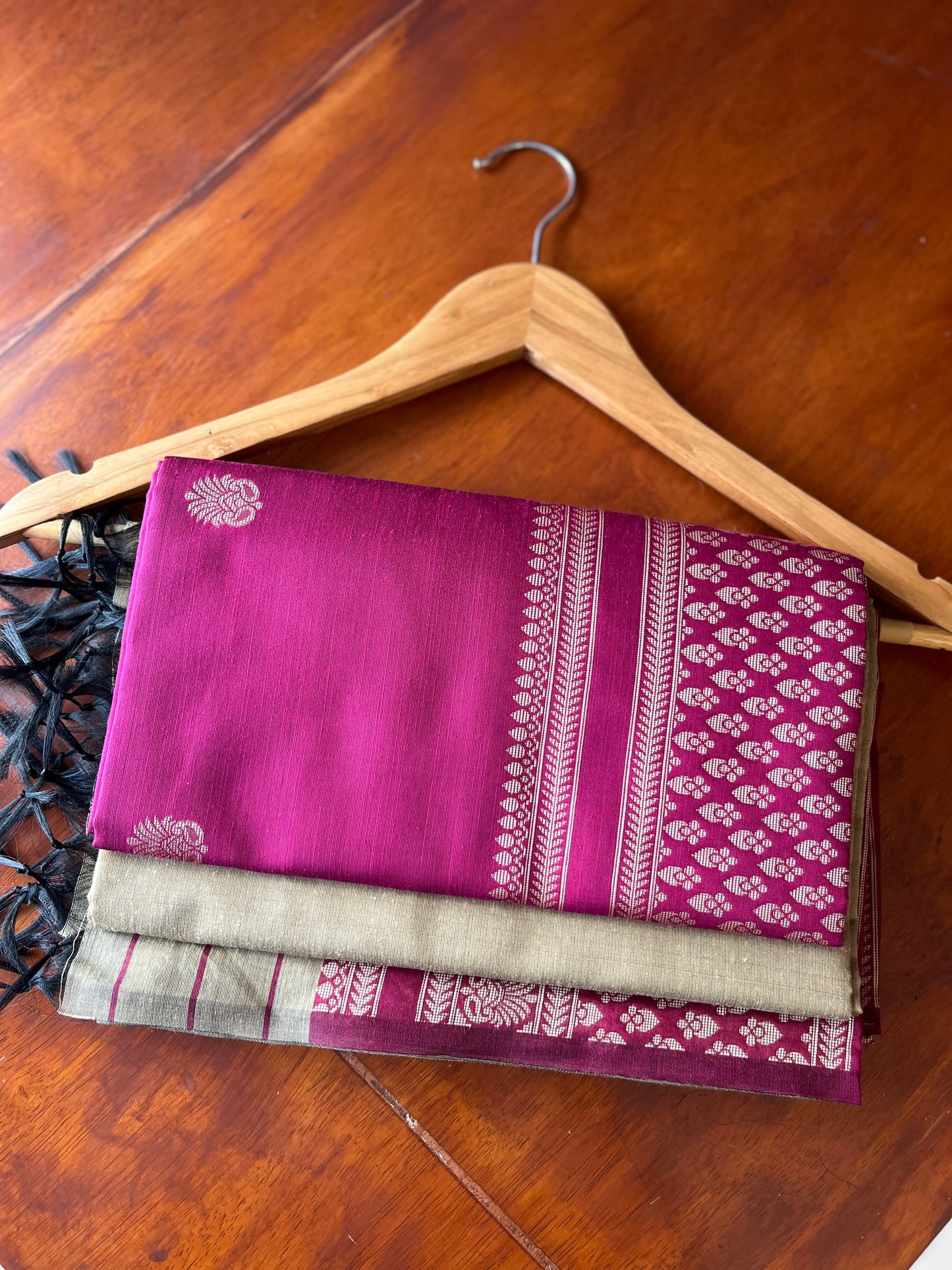 Folded Dark Pink three-piece unstitched suit fabrics showing woven motifs, decorative border and contrasting fabric.